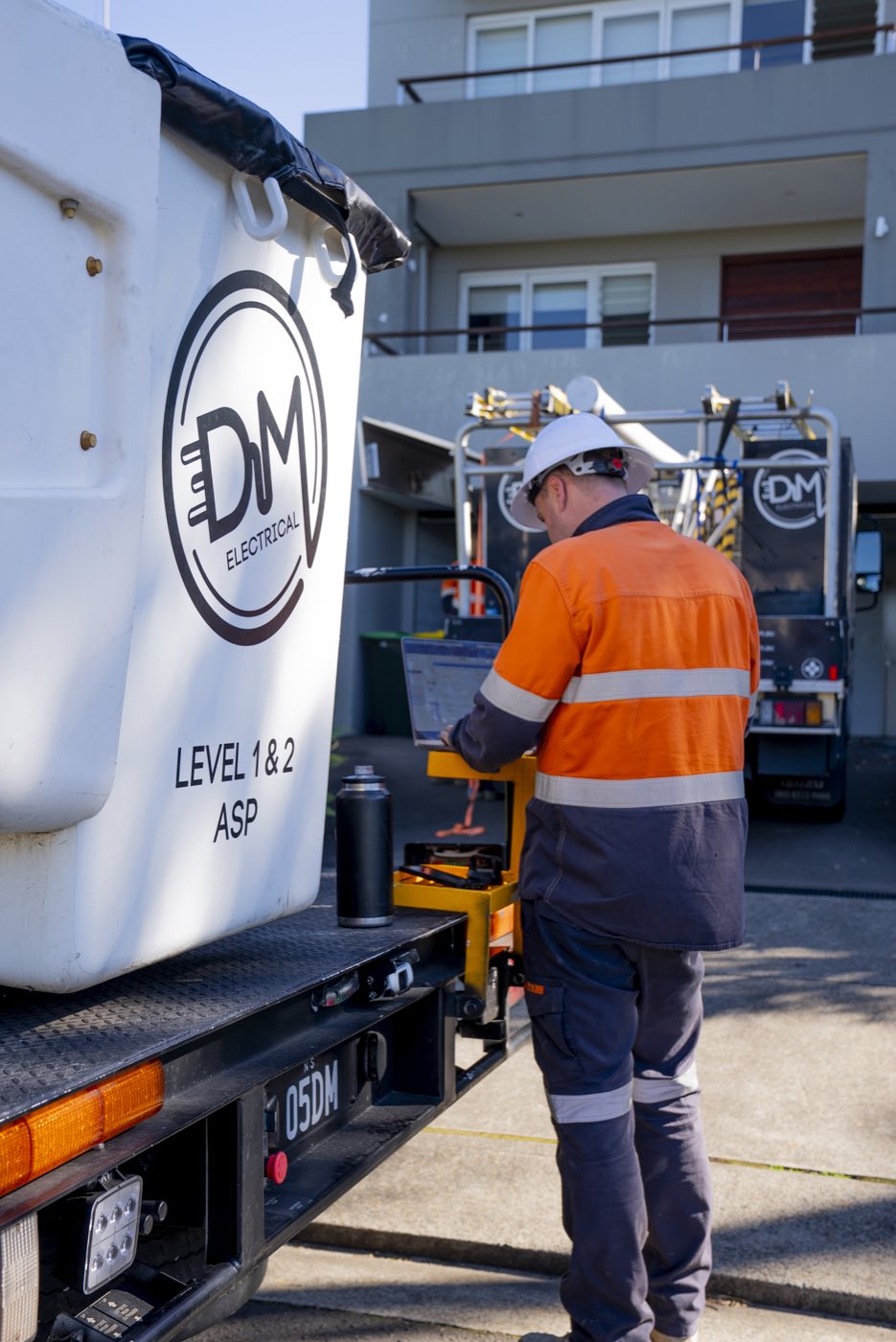 DM Electrical Level 1 and 2 ASP service truck with an electrician working at the tailgate on a Sydney job